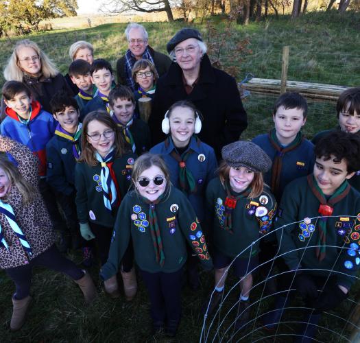 Philip Pullman with tree and children in the background