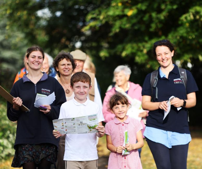 a group of people on a walk with trees on the background